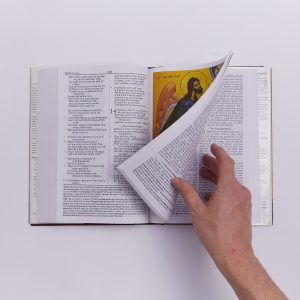 hand turning the page of bible